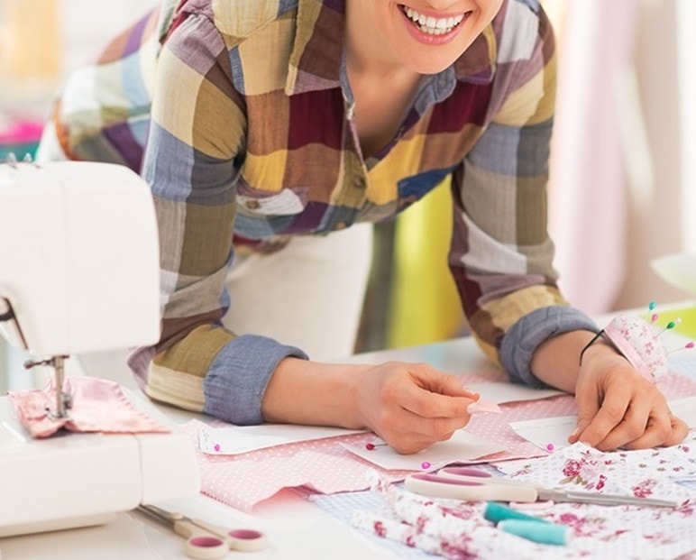 Maker smiling while working on a sewing project with Wrights notions